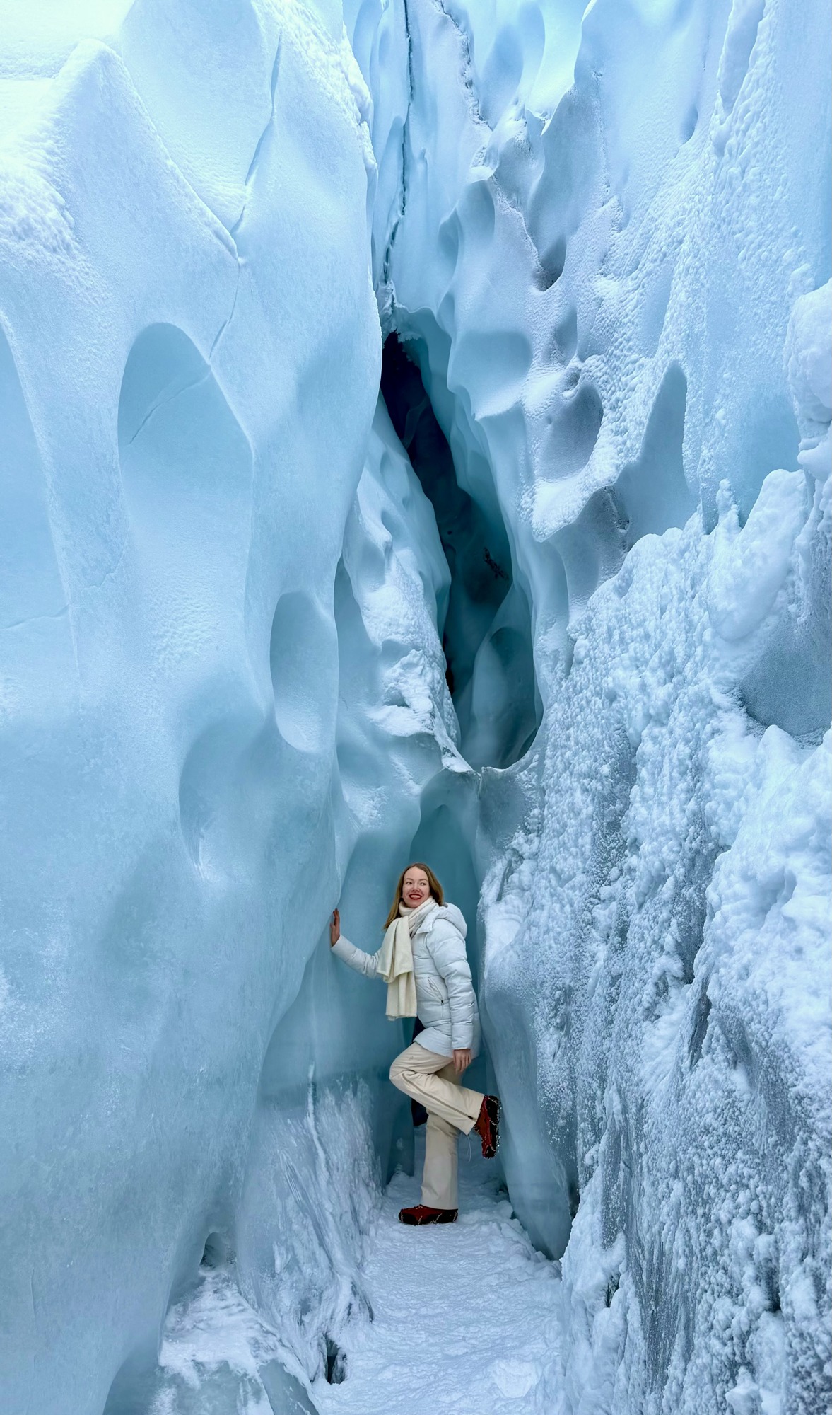 Anya exploring a passage between towering blue glacier walls